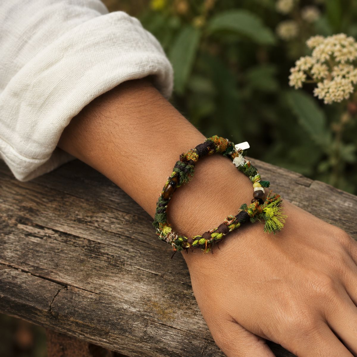 AI-generated styling illustration of the Forest Trace forest green and brown bracelet worn on a wrist.
