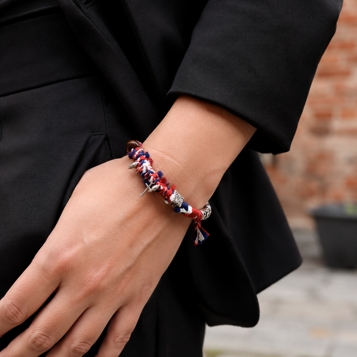AI-generated styling illustration of the Northward red, navy and white bracelet worn on a wrist.